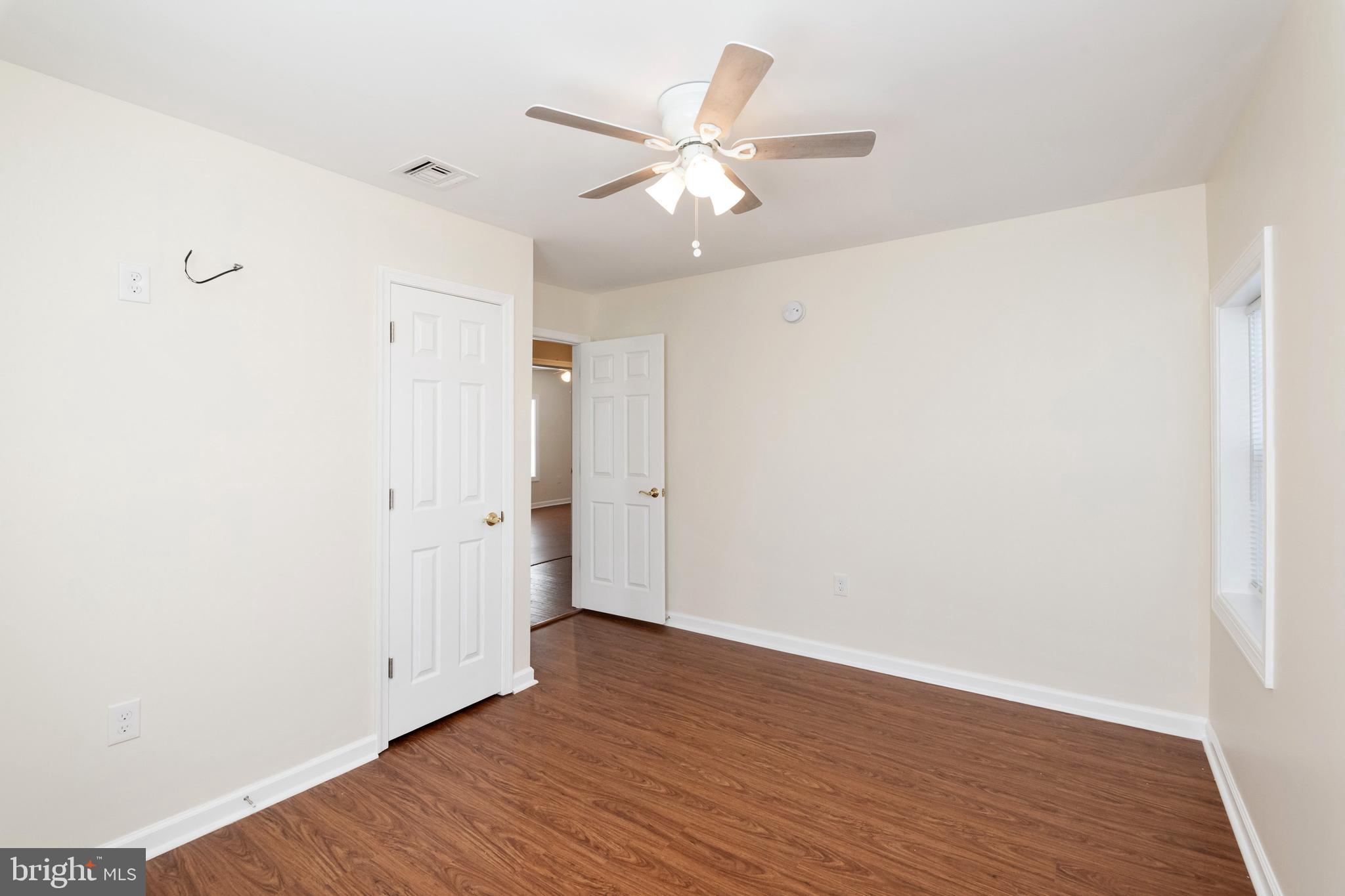 2505 Hammonds Ferry Road Baltimore, MD 21227 - Photo 30 of 36 an empty room with wooden floor and a ceiling fan