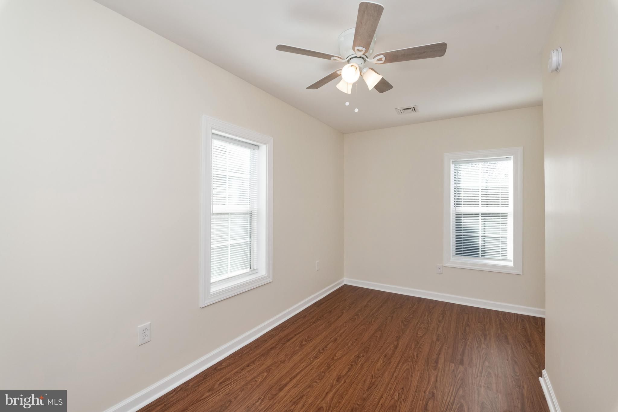2505 Hammonds Ferry Road Baltimore, MD 21227 - Photo 31 of 36 an empty room with wooden floor windows and fan