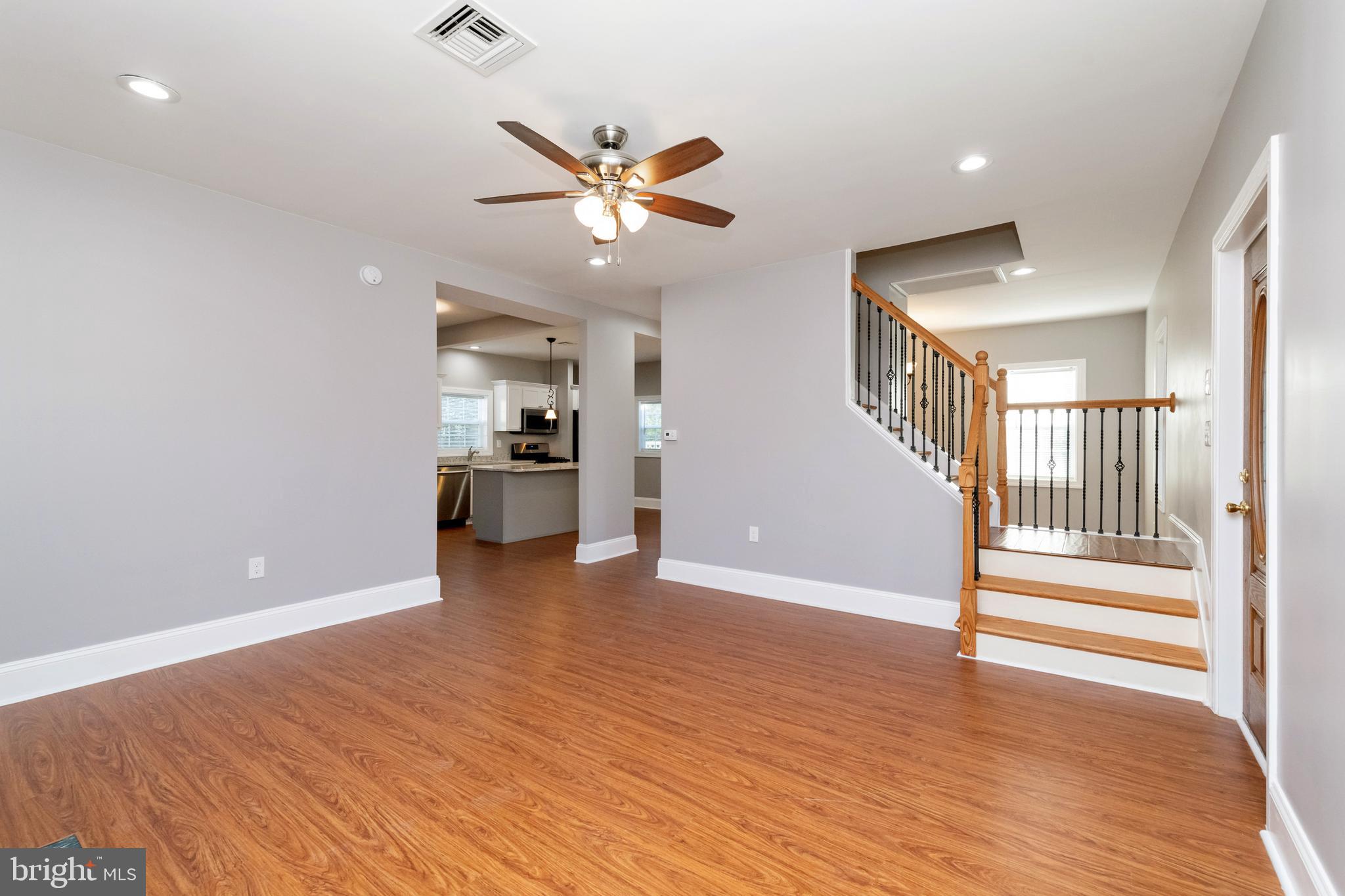 2505 Hammonds Ferry Road Baltimore, MD 21227 - Photo 9 of 36 an empty room with wooden floor fan and windows