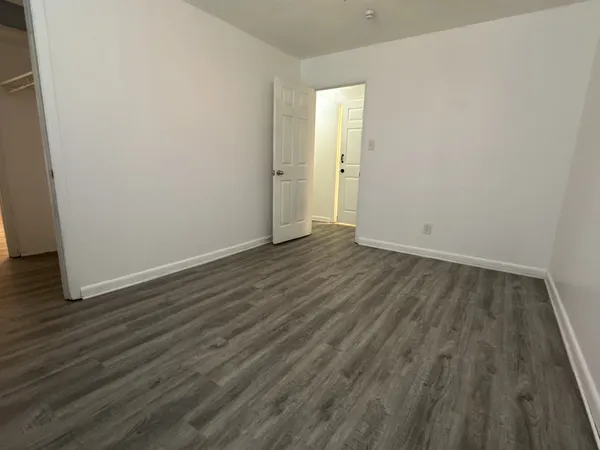a view of empty room with wooden floor