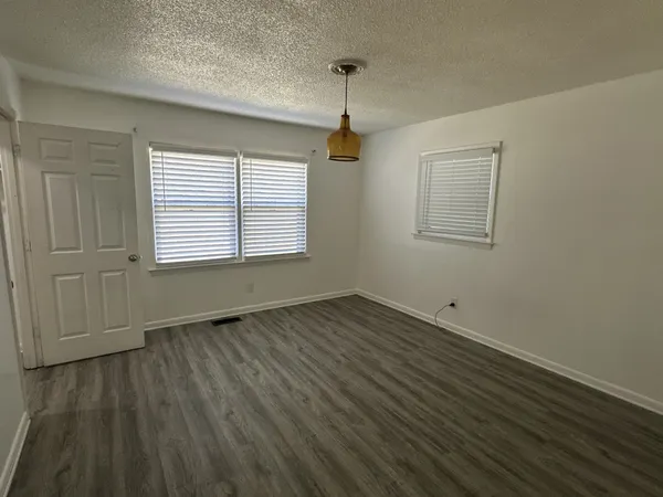 a view of a hallway with wooden floor and a window