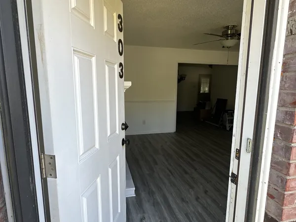 a view of a hallway with wooden floor and staircase