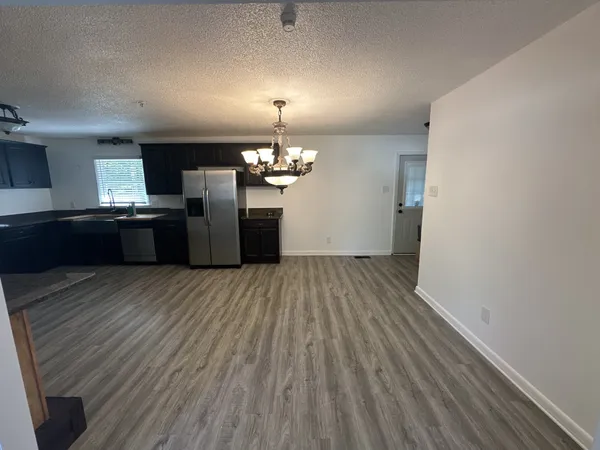 a kitchen with stainless steel appliances granite countertop a refrigerator a stove and a wooden floors