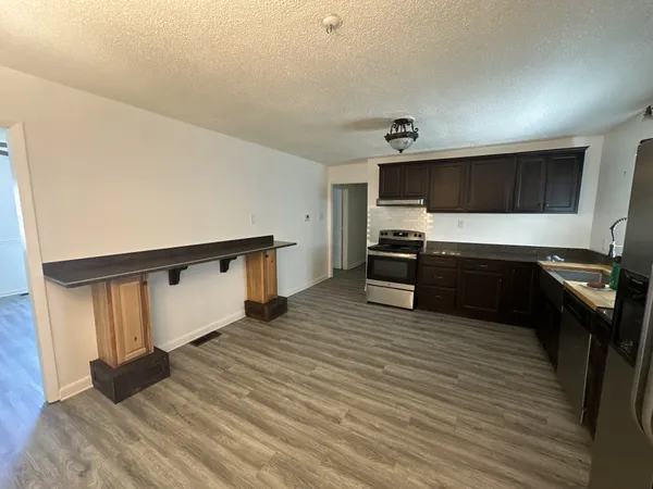 a large kitchen with a sink and stainless steel appliances