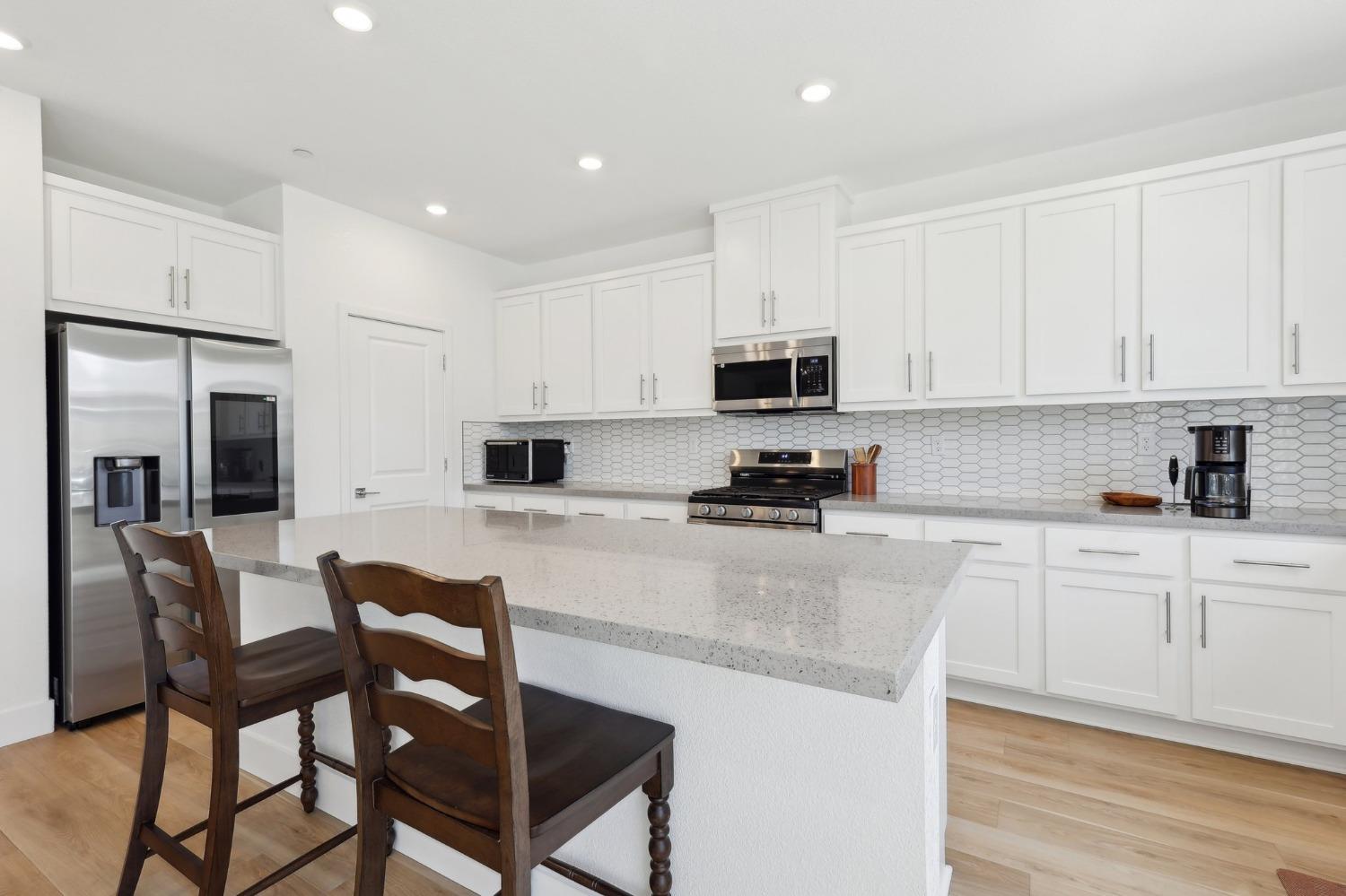 2200 Stagecoach Road Patterson, CA 95363 - Photo 12 of 35 a kitchen with stainless steel appliances granite countertop a stove a sink a refrigerator white cabinets and a granite counter top