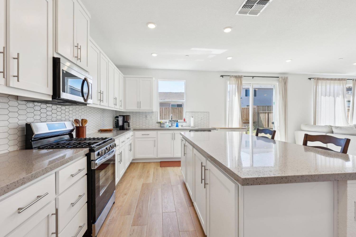 2200 Stagecoach Road Patterson, CA 95363 - Photo 15 of 35 a kitchen with granite countertop a sink a stove and cabinets