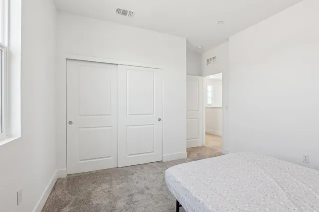 a spacious bedroom with a bed and cabinet