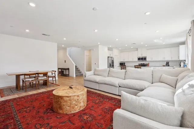 a living room with furniture kitchen view and a dining table