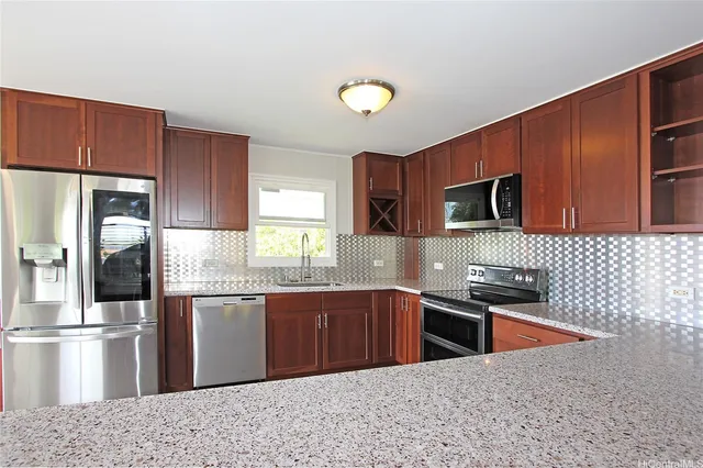 a kitchen with stainless steel appliances granite countertop a sink stove and refrigerator