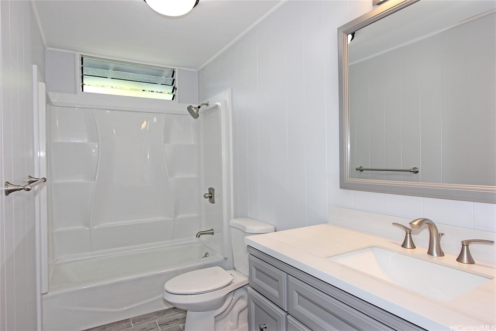 3647 Aliamanu Street Honolulu, HI 96818 - Photo 7 of 16 a bathroom with a granite countertop sink a toilet and shower