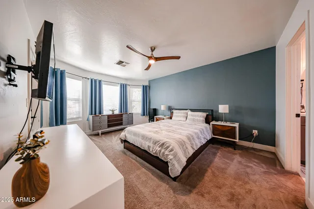 a spacious bedroom with a bed and a large mirror