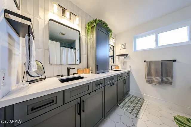 a spacious bathroom with a double vanity sink and mirror