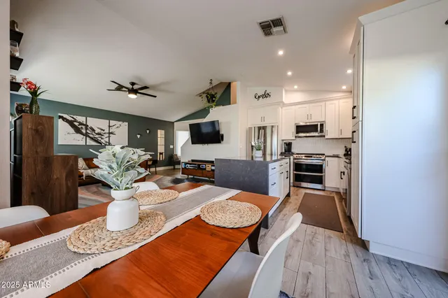 a kitchen with a table chairs stove and refrigerator