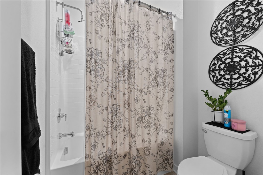 36938 Frantoio Street Beaumont, CA 92223 - Photo 25 of 35 a bathroom with a toilet and a shower curtain