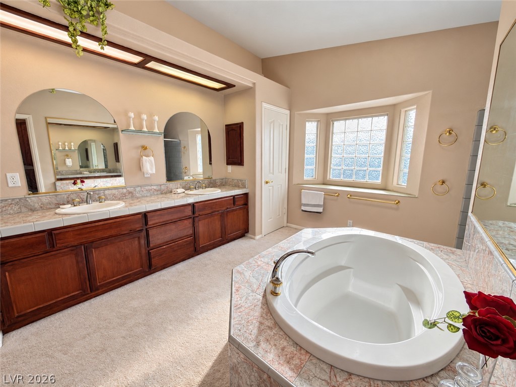 5470 Grain Mill Road Pahrump, NV 89061 - Photo 30 of 80 An inviting soaking tub pairs with a double vanity and a glass-block bay window.