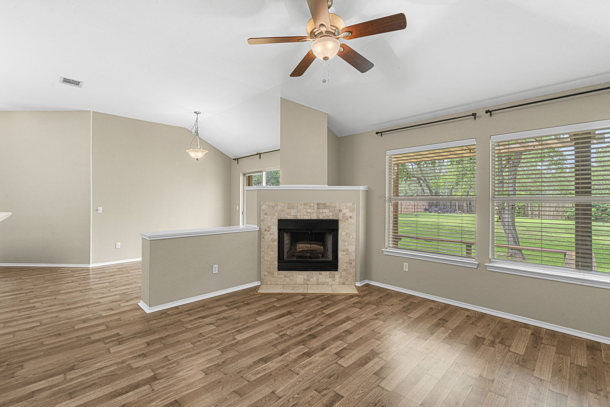 7172 Ridge Oak Road Austin, TX 78749 - Photo 27 of 40 A warm ambiance fills this inviting living area, featuring a cozy fireplace and views of the verdant yard.