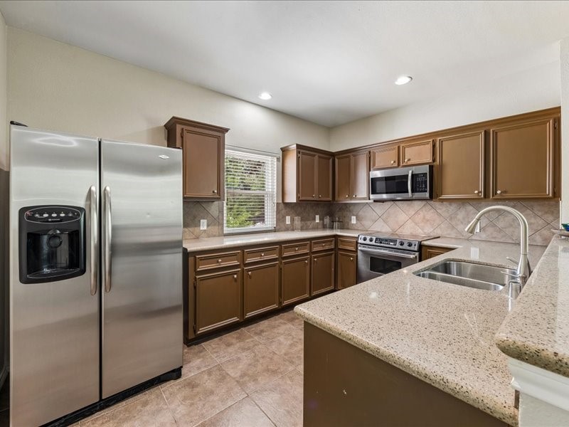 2915 Clay Street Houston, TX 77003 - Photo 2 of 15 Well-appointed kitchen featuring granite countertops, stainless steel appliances, ample cabinetry, and a functional layout.
