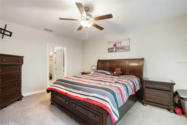 a bedroom with a bed and a ceiling fan