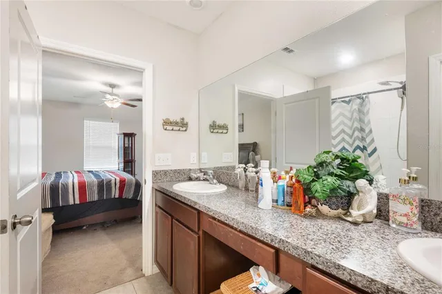 a en suite bathroom with a granite countertop sink and a mirror