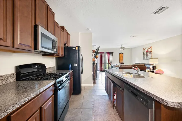 a kitchen with stainless steel appliances granite countertop a stove a sink dishwasher and a refrigerator