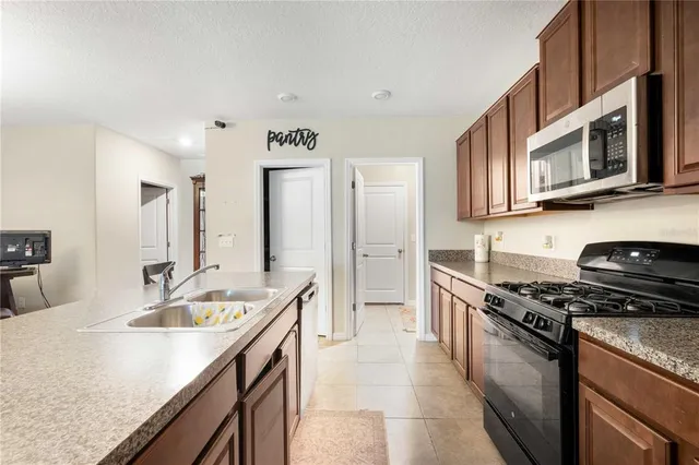 a kitchen with a sink stove top oven and refrigerator