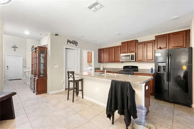 a kitchen with granite countertop a refrigerator and a sink