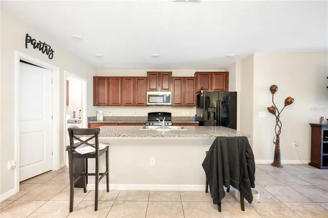 a kitchen with a refrigerator and a stove top oven