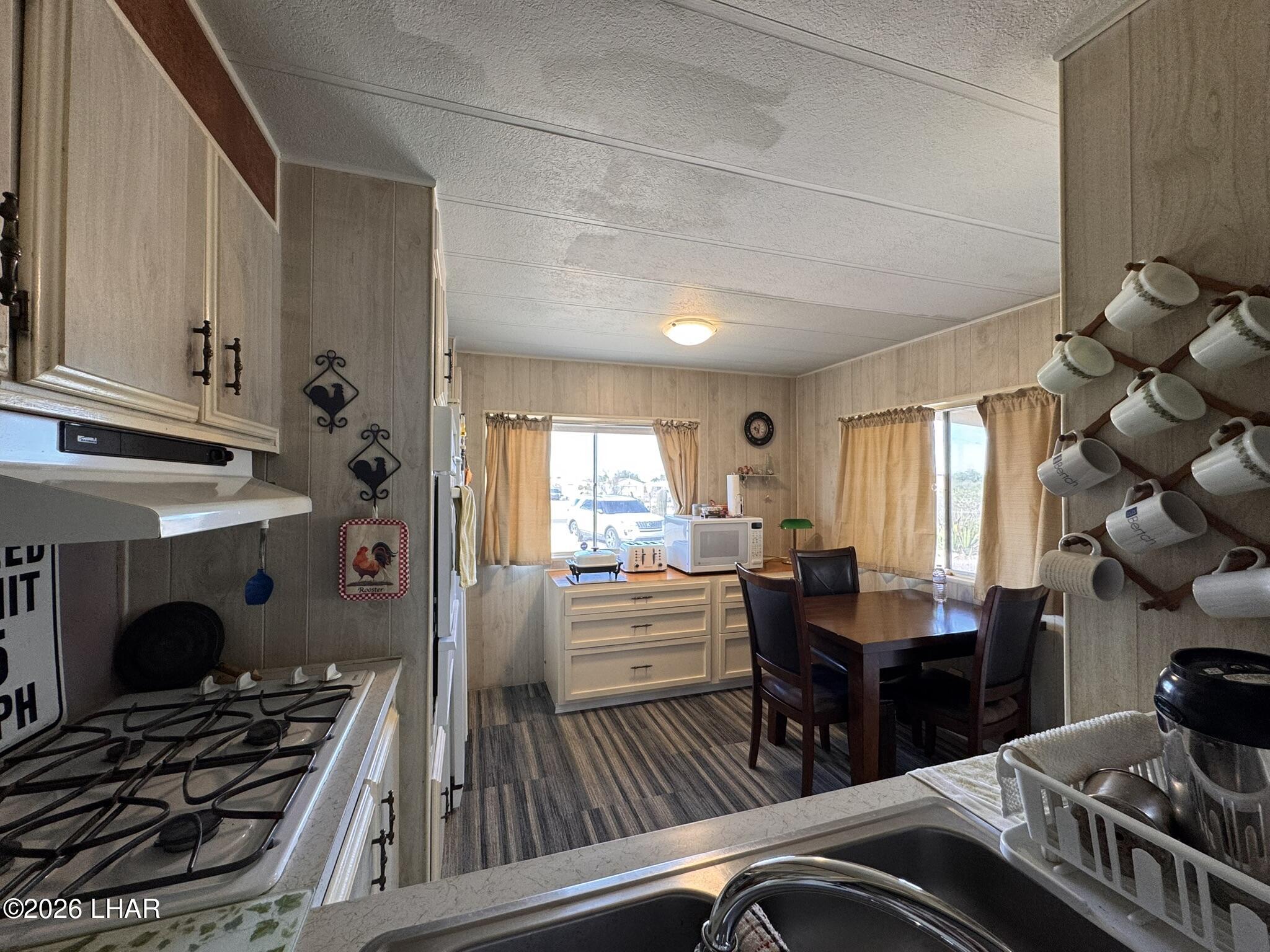 587 West Pyramid Street Quartzsite, AZ 85346 - Photo 15 of 46 a kitchen with a stove and white cabinets