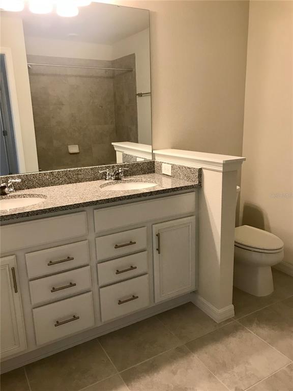 2680 Mead Avenue St. Cloud, FL 34771 - Photo 16 of 35 a bathroom with a granite countertop sink toilet and mirror