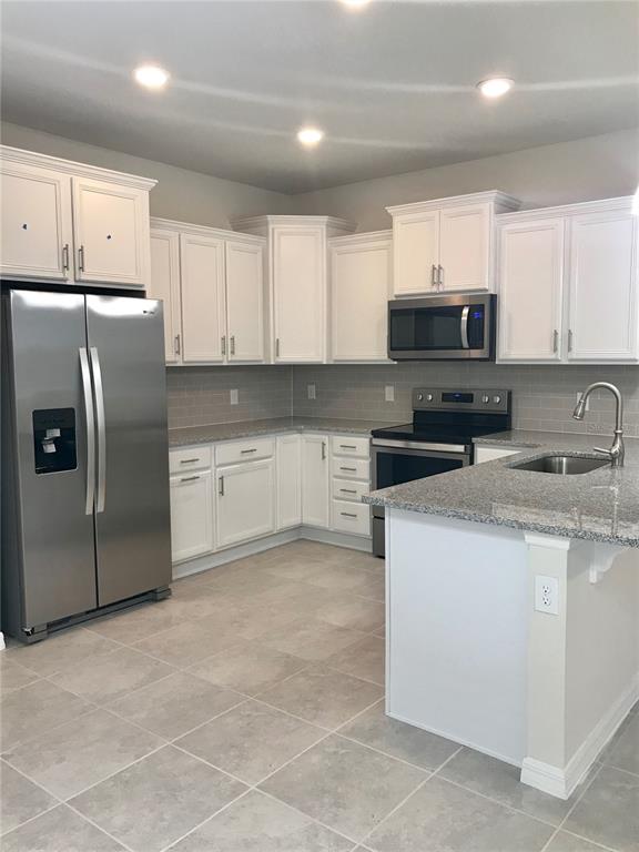2680 Mead Avenue St. Cloud, FL 34771 - Photo 5 of 35 a kitchen with stainless steel appliances granite countertop a refrigerator stove a sink and a microwave