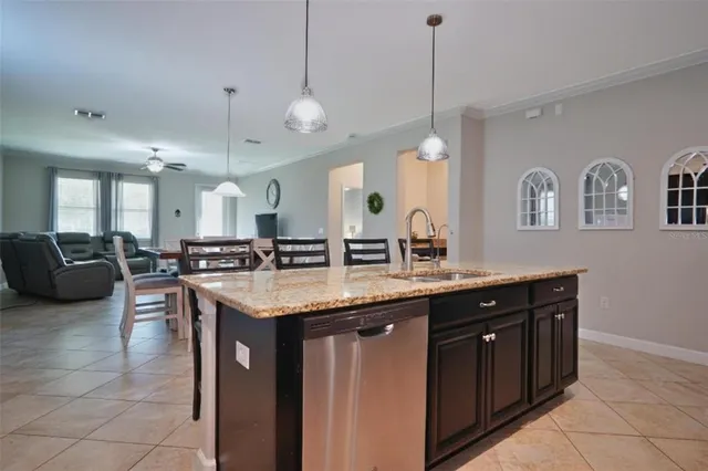 a kitchen with a counter space a sink and living room view