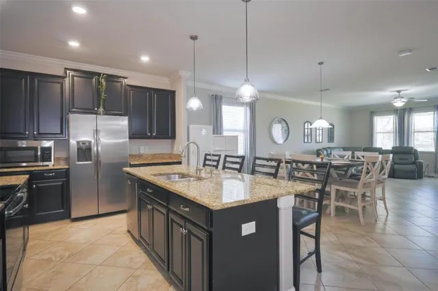 a kitchen with granite countertop a sink a counter top stainless steel appliances and cabinets