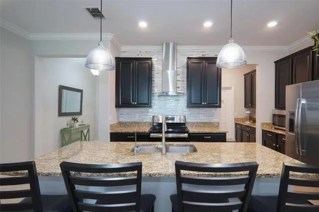 a kitchen with two sink a counter space stainless steel appliances and cabinets