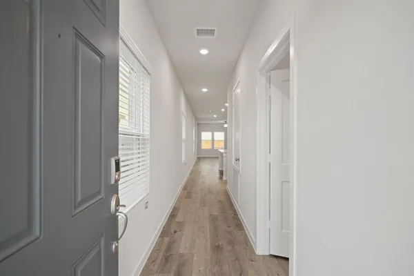 a view of a hallway with wooden floor and staircase