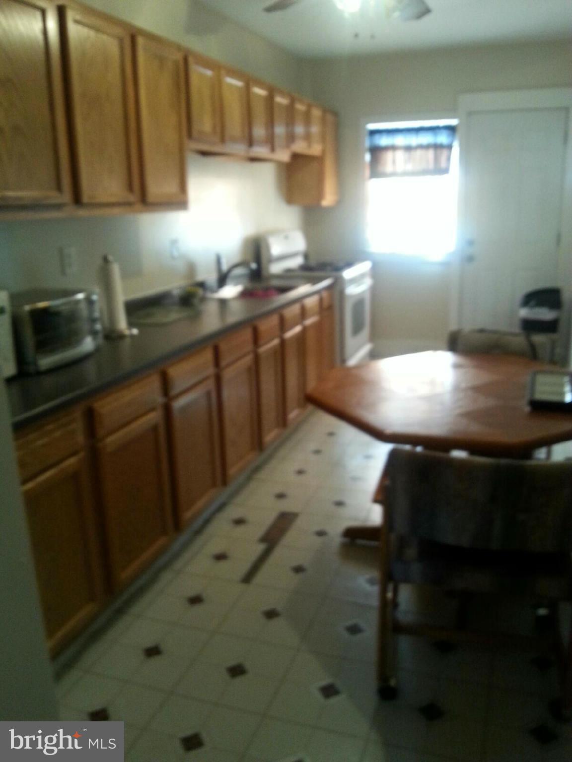 1419 Northgate Road Baltimore, MD 21218 - Photo 2 of 8 a kitchen with kitchen island a sink stove and cabinets