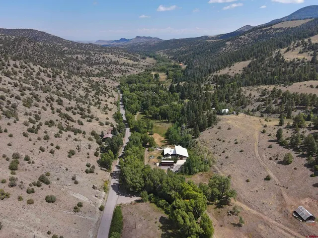 an aerial view of a house with swimming pool and lake view