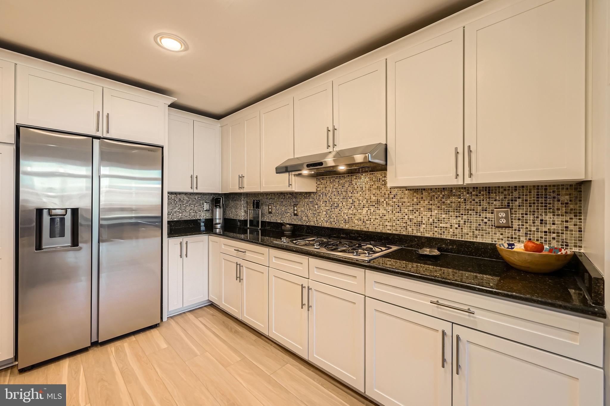 1400 Lancaster Street, Unit 303 Baltimore, MD 21231 - Photo 11 of 36 a kitchen with stainless steel appliances granite countertop a sink a refrigerator and white cabinets