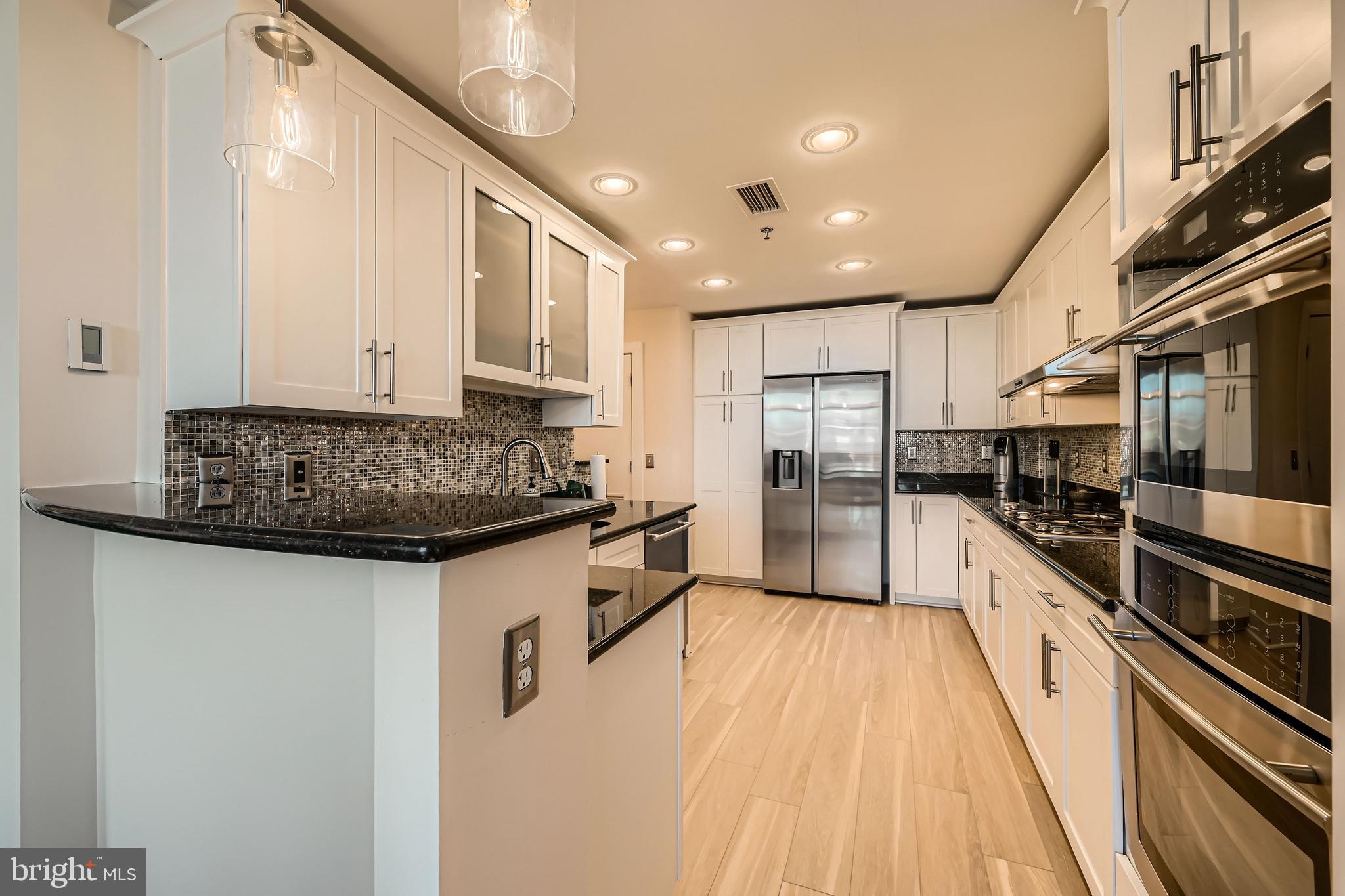 1400 Lancaster Street, Unit 303 Baltimore, MD 21231 - Photo 9 of 36 a kitchen with stainless steel appliances granite countertop a stove a sink and a refrigerator