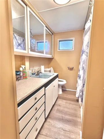 a bathroom with a sink a toilet and a window