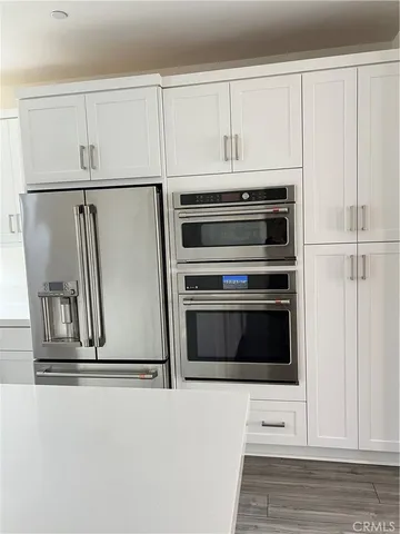 a kitchen with white cabinets and white appliances