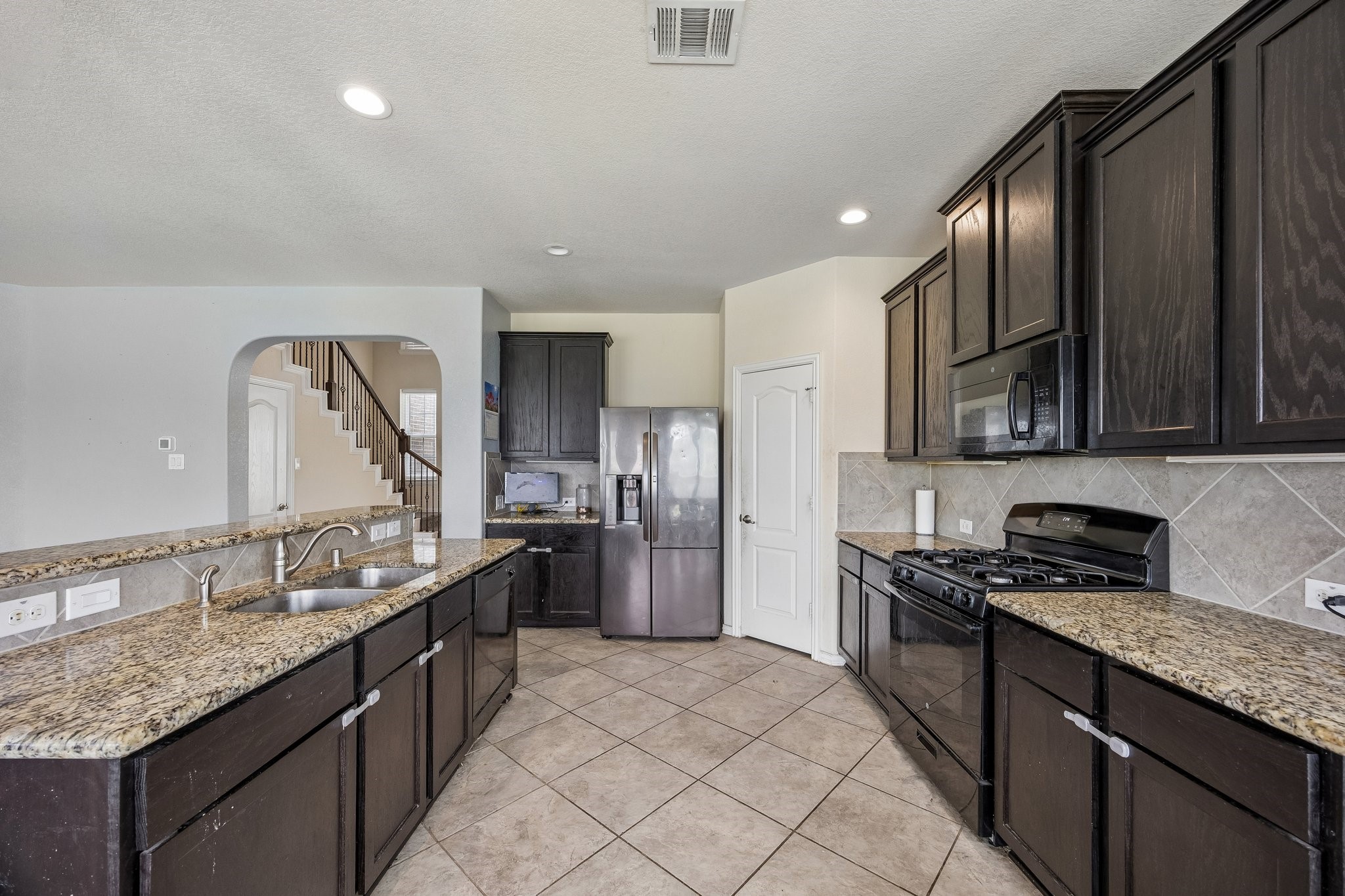 9707 Shimmering Lakes Drive Rosharon, TX 77583 - Photo 3 of 15 a kitchen with stainless steel appliances granite countertop a sink stove and refrigerator