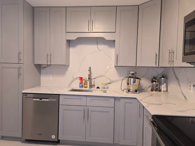 a kitchen with a sink dishwasher and cabinets
