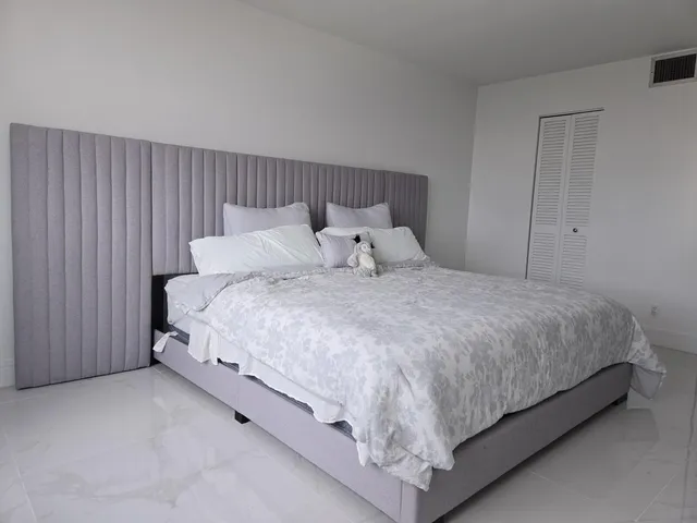 a large bed sitting in a bedroom next to a cabinet