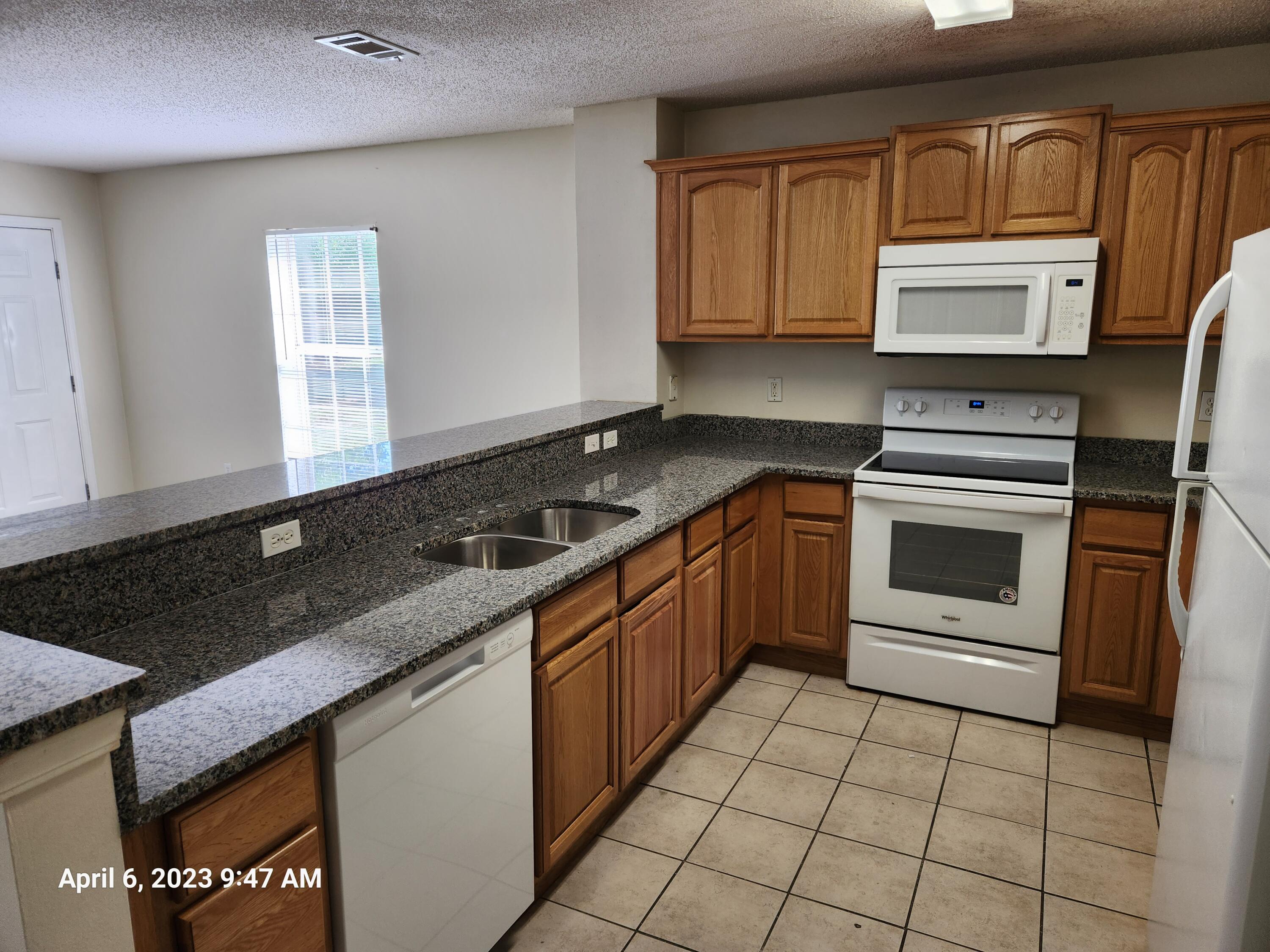 204 Johnson Court Crestview, FL 32536 - Photo 16 of 17 a kitchen with stainless steel appliances granite countertop a sink stove and microwave