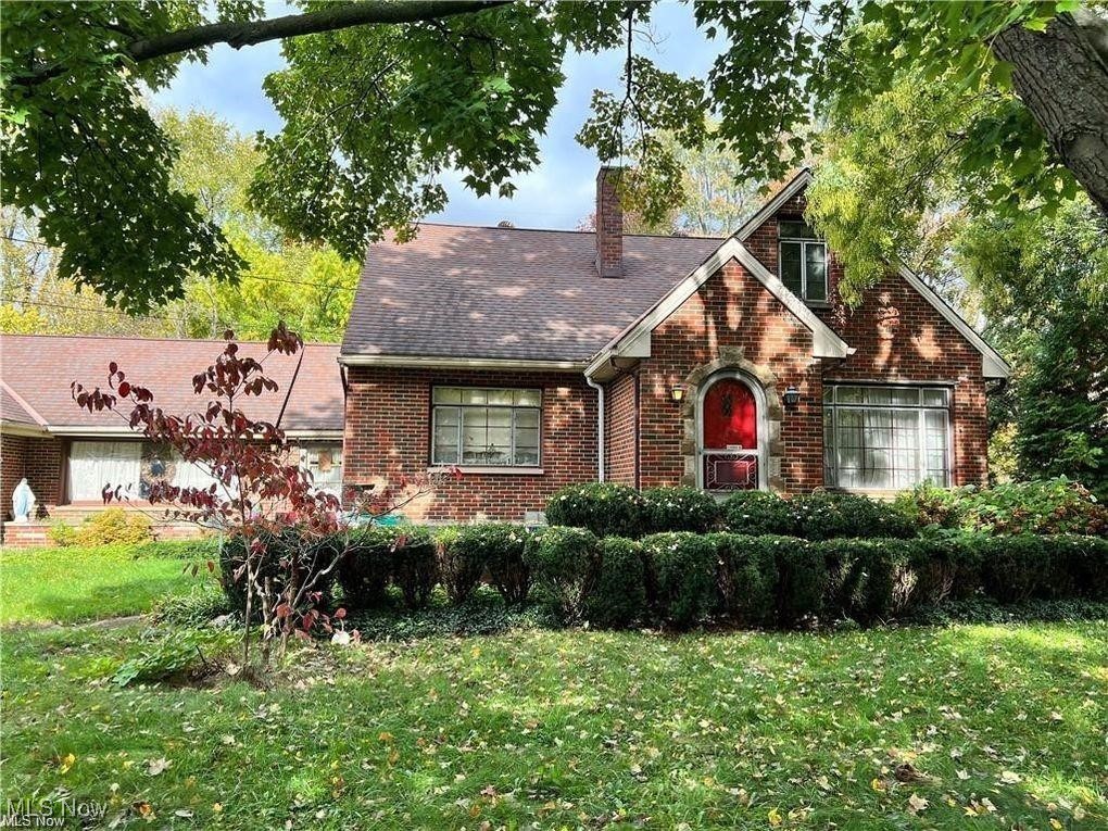 8581 Fair Road Strongsville, OH 44149 - Photo 1 of 20 English style home featuring a front yard, brick siding, a chimney, and roof with shingles