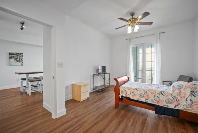 a bedroom with a bed and wooden floor
