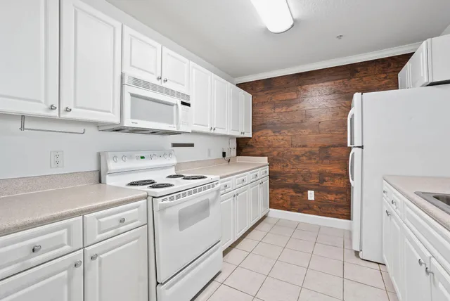 a kitchen with white cabinets and white appliances