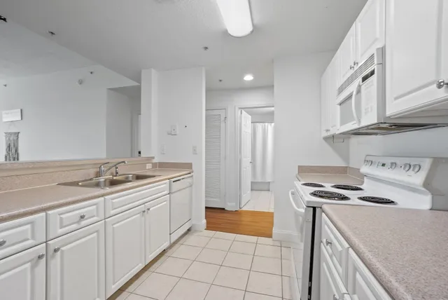 a kitchen with granite countertop a sink stove and cabinets