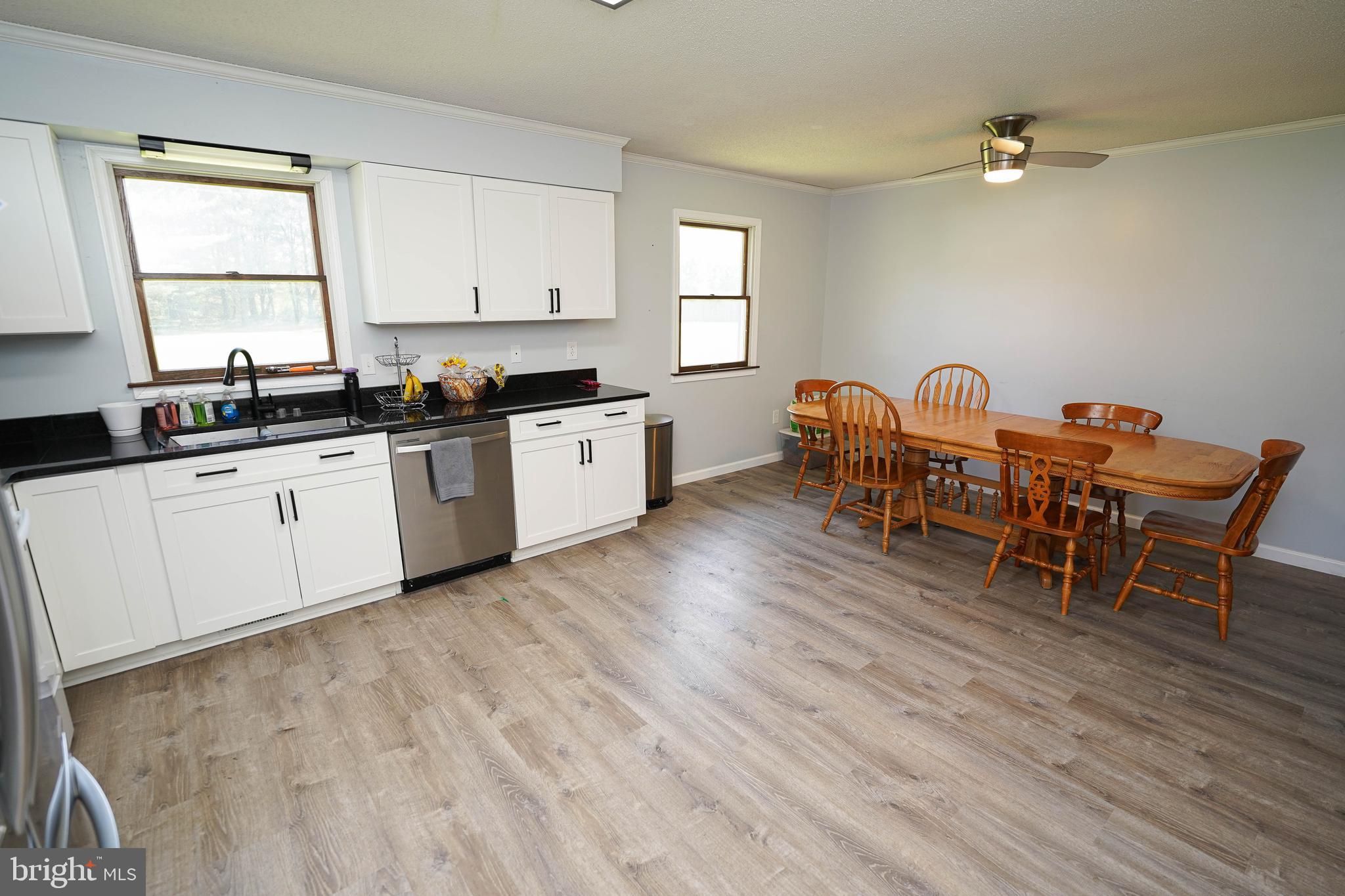 10564 Waller Road Laurel, DE 19956 - Photo 13 of 33 a kitchen with granite countertop a dining table chairs sink and cabinets
