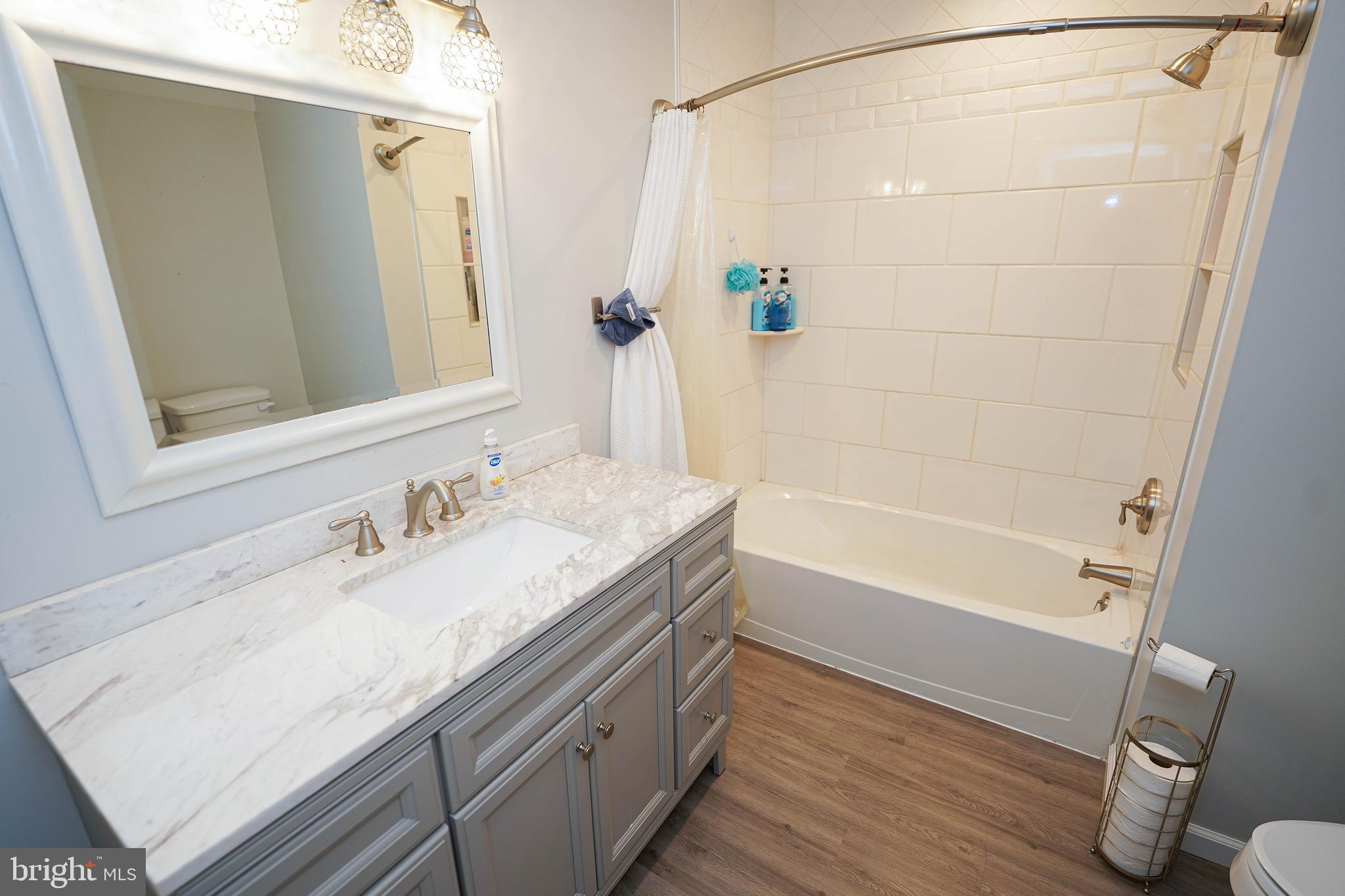 10564 Waller Road Laurel, DE 19956 - Photo 24 of 33 a bathroom with a granite countertop sink a mirror and a bathtub